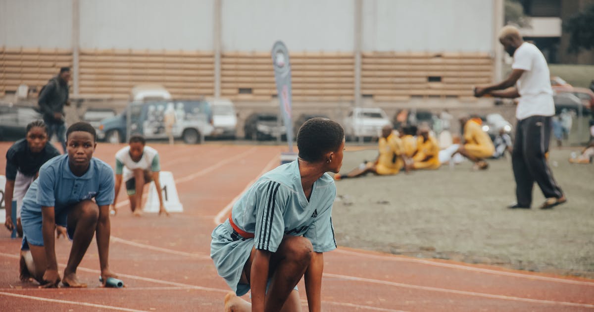 Group of young athletes preparing to compete on an outdoor track