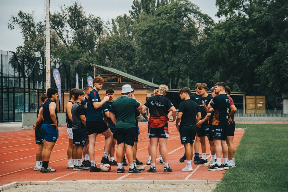 Group of young athletes in a training session on an outdoor running track.