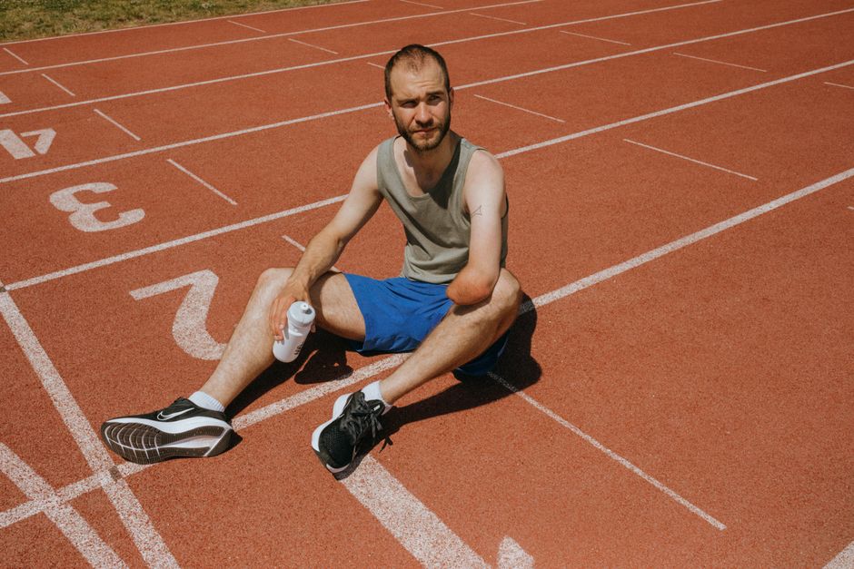 Track and field athlete drinking water during a break at a meet