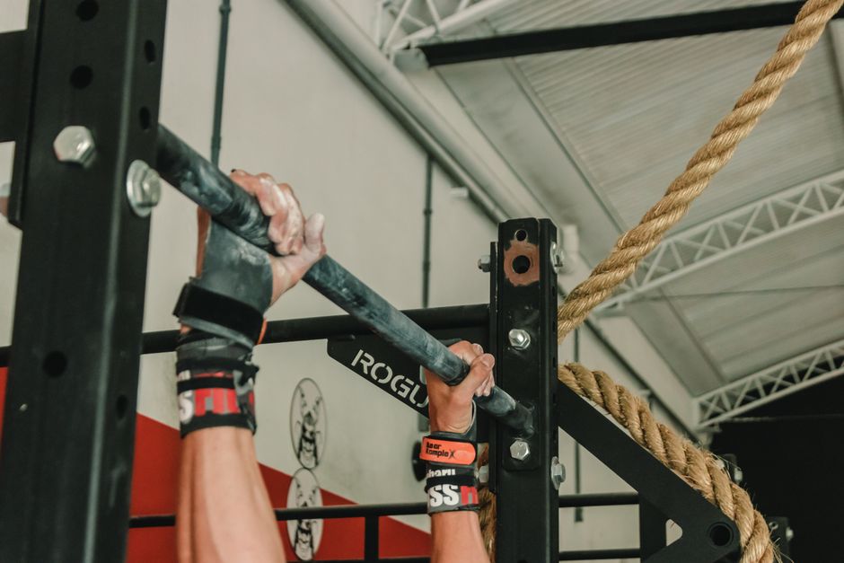 Close-up of hands gripping pull-up bar during an intense gym workout session.