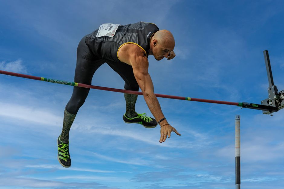 Athlete in action during a pole vault event, showcasing strength and agility.